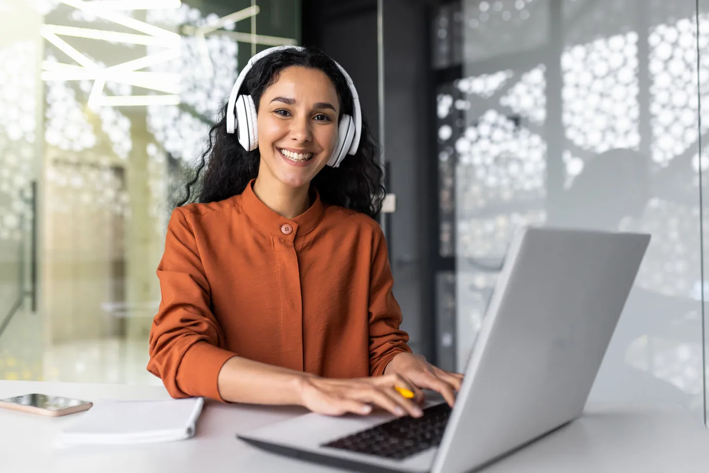 Profissional atendendo com headset em frente ao notebook
